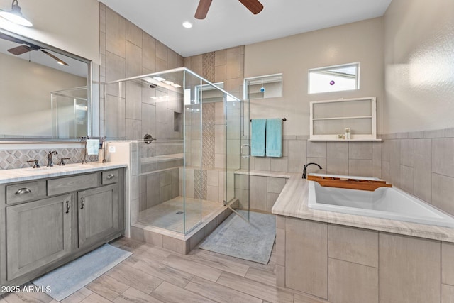 bathroom with ceiling fan, vanity, and independent shower and bath