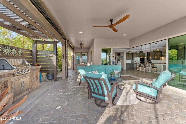 view of patio with an outdoor kitchen, area for grilling, ceiling fan, a pergola, and an outdoor living space