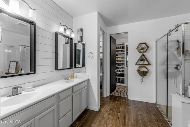 full bath with a shower stall, a sink, and wood finished floors