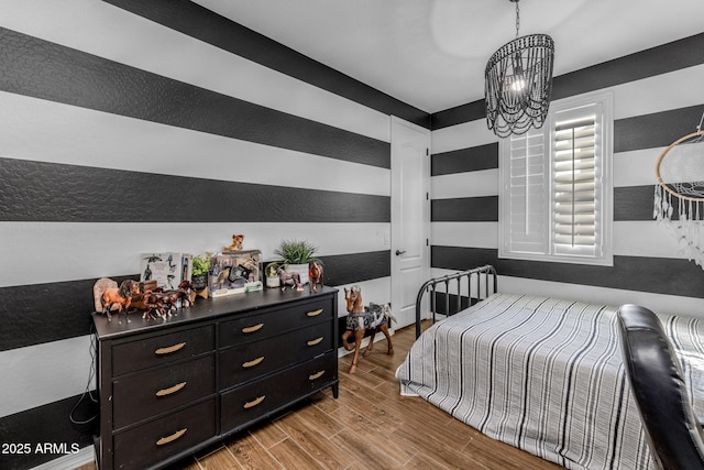 bedroom with a chandelier and wood finished floors