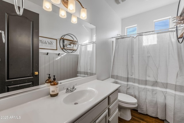 full bath featuring curtained shower, vanity, toilet, and wood finished floors