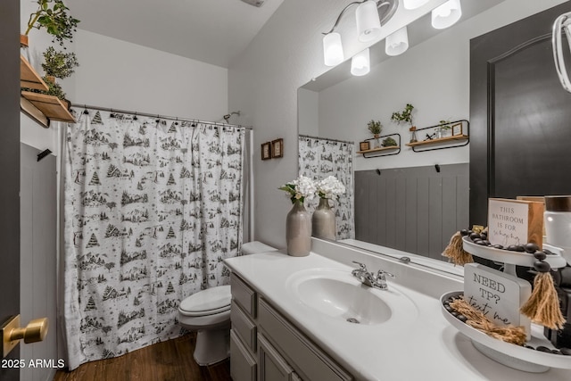 full bath with toilet, a shower with curtain, wood finished floors, and vanity