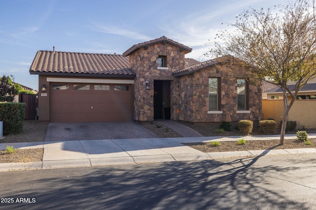 mediterranean / spanish home featuring stucco siding, a garage, stone siding, driveway, and a tiled roof