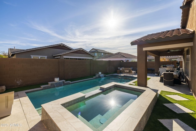 view of pool featuring a patio, a pool with connected hot tub, ceiling fan, exterior kitchen, and a fenced backyard