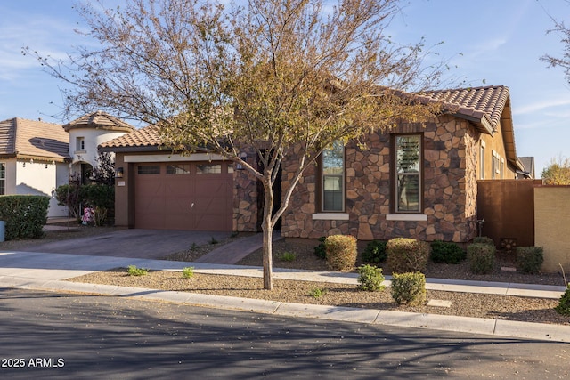 view of front of home featuring a garage, a tiled roof, stone siding, driveway, and stucco siding