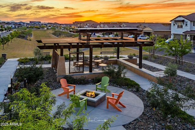 patio terrace at dusk with an outdoor fire pit and a residential view