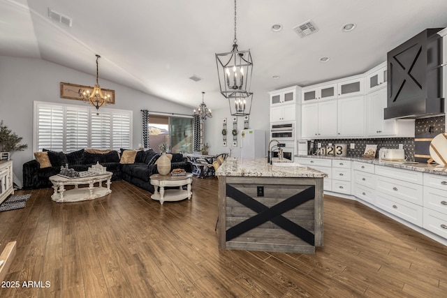 kitchen featuring dark wood-style flooring, visible vents, open floor plan, and a notable chandelier