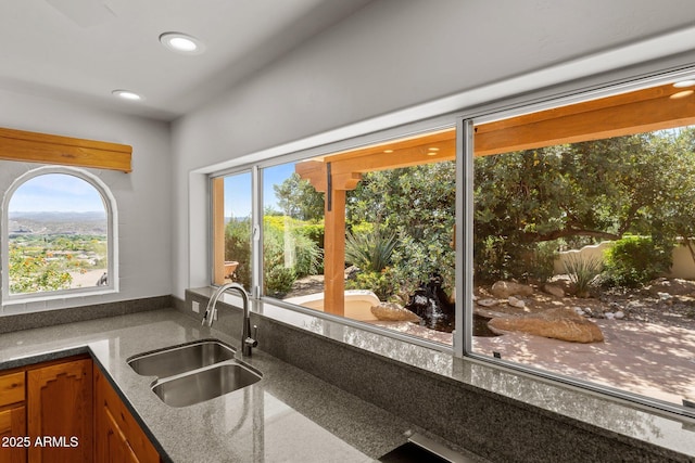 651 Chaparral Rd, Wickenburg, AZ 85390 - kitchen with brown cabinetry, a sink, dark stone countertops, and plenty of natural light