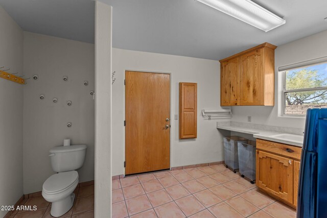 651 Chaparral Rd, Wickenburg, AZ 85390 - kitchen featuring light countertops, baseboards, built in study area, freestanding refrigerator, and light tile patterned flooring