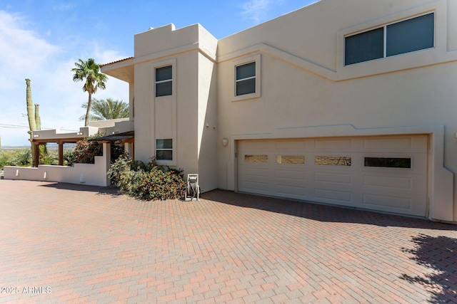 651 Chaparral Rd, Wickenburg, AZ 85390 - view of front of house with stucco siding, an attached garage, and decorative driveway