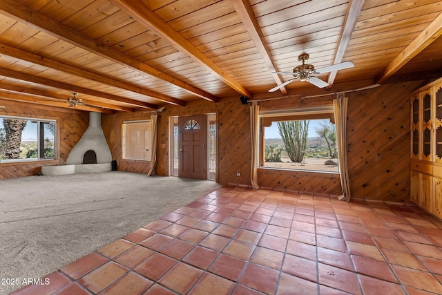 651 Chaparral Rd, Wickenburg, AZ 85390 - unfurnished living room with a wood stove, wood walls, beam ceiling, ceiling fan, and wood ceiling