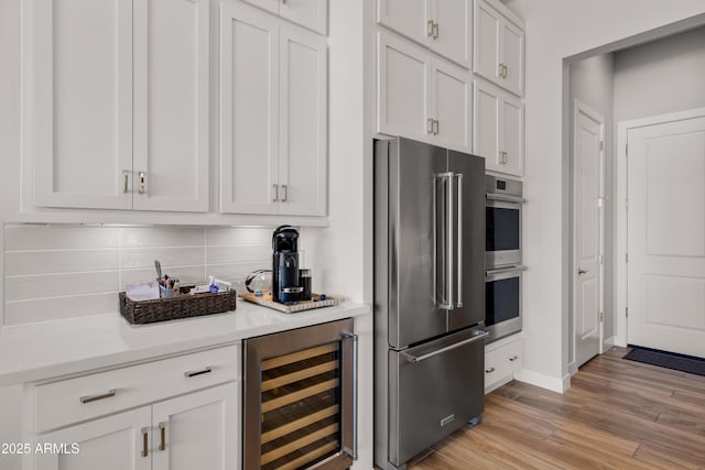 16134 E Ridgestone Dr, Fountain Hills, AZ 85268 - kitchen featuring appliances with stainless steel finishes, beverage cooler, light countertops, light wood-type flooring, and white cabinets
