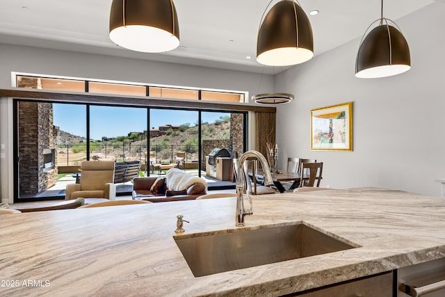 16134 E Ridgestone Dr, Fountain Hills, AZ 85268 - kitchen with light stone counters, hanging light fixtures, a towering ceiling, and recessed lighting
