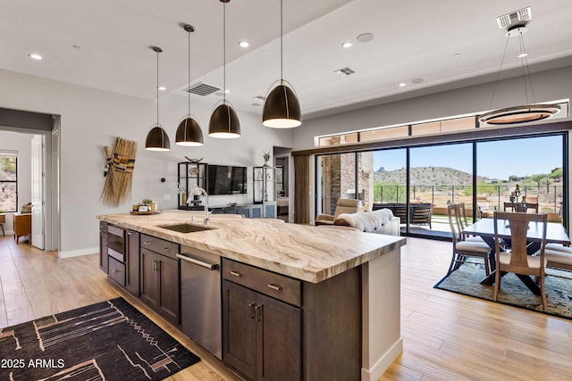16134 E Ridgestone Dr, Fountain Hills, AZ 85268 - kitchen with dark brown cabinetry, healthy amount of natural light, light wood-style flooring, an island with sink, and recessed lighting