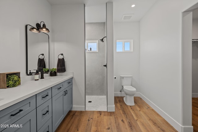 bathroom featuring vanity, toilet, hardwood / wood-style floors, and walk in shower