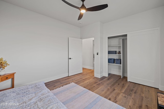 bedroom with wood-type flooring, a closet, and ceiling fan