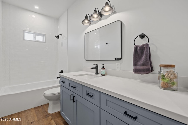 full bathroom featuring vanity, tiled shower / bath, hardwood / wood-style floors, and toilet