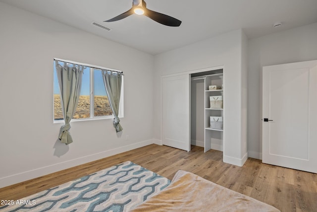 bedroom with ceiling fan, a closet, and light hardwood / wood-style flooring