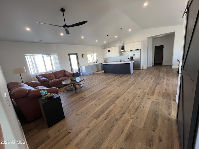 living room with high vaulted ceiling, hardwood / wood-style floors, and ceiling fan