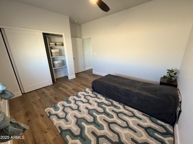 bedroom with ceiling fan, dark hardwood / wood-style flooring, and a closet