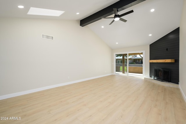 unfurnished living room with a large fireplace, ceiling fan, light hardwood / wood-style floors, and vaulted ceiling with skylight