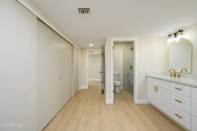 bathroom featuring hardwood / wood-style floors, toilet, vanity, and an enclosed shower