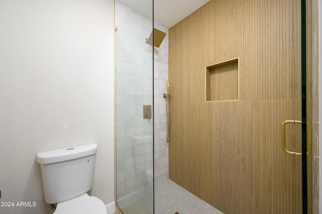 bathroom with toilet and a shower with door