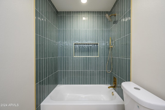 bathroom with toilet and tiled shower / bath