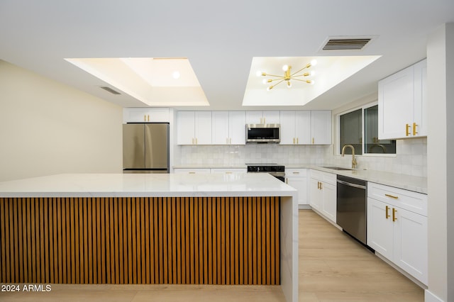 kitchen featuring light stone counters, sink, white cabinetry, and appliances with stainless steel finishes