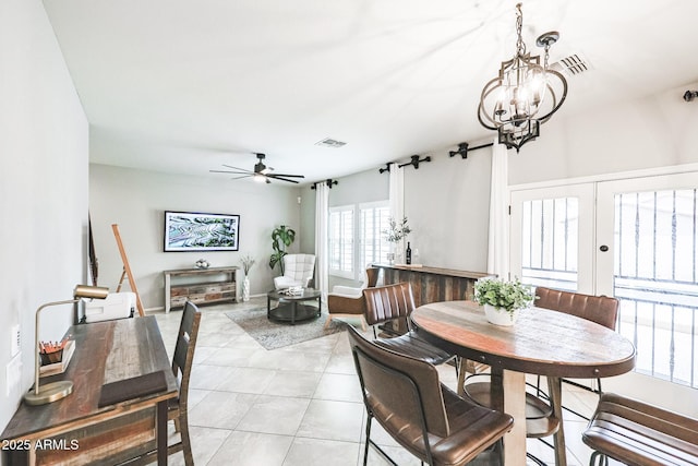 dining room featuring ceiling fan with notable chandelier, french doors, and light tile patterned flooring