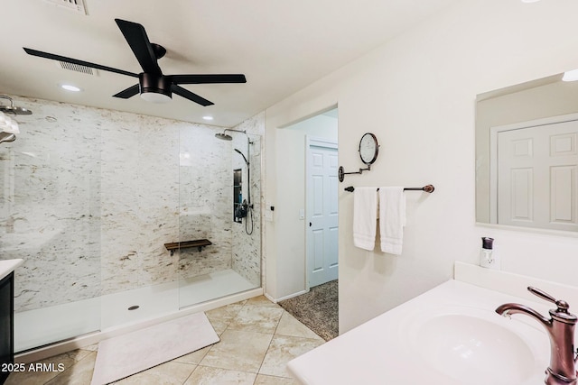 bathroom with vanity, ceiling fan, and a tile shower