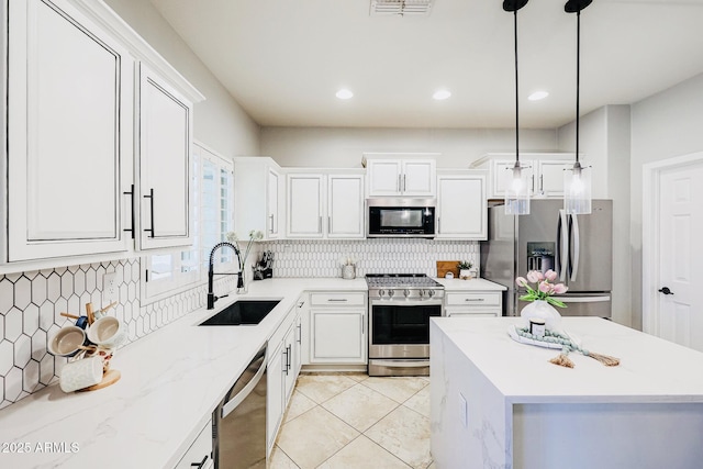 kitchen with pendant lighting, sink, white cabinetry, and stainless steel appliances