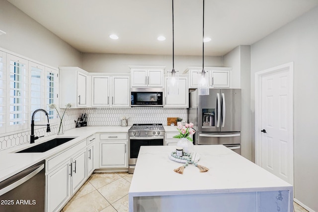 kitchen featuring a kitchen island, appliances with stainless steel finishes, white cabinetry, sink, and hanging light fixtures