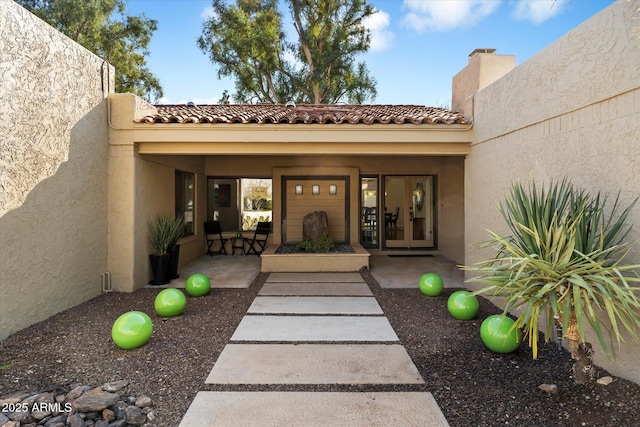 view of exterior entry with a patio area