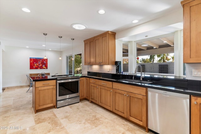 kitchen with kitchen peninsula, appliances with stainless steel finishes, a healthy amount of sunlight, pendant lighting, and sink