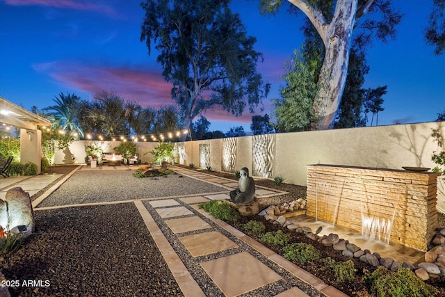 yard at dusk with a patio area