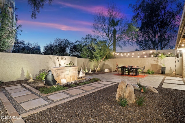 yard at dusk featuring a patio