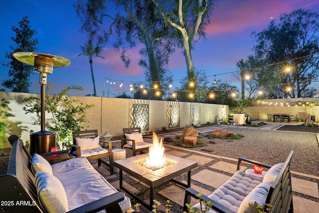 patio terrace at dusk with an outdoor living space with a fire pit