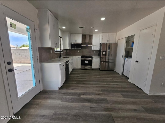 kitchen with wall chimney exhaust hood, stainless steel appliances, sink, washer / clothes dryer, and white cabinetry