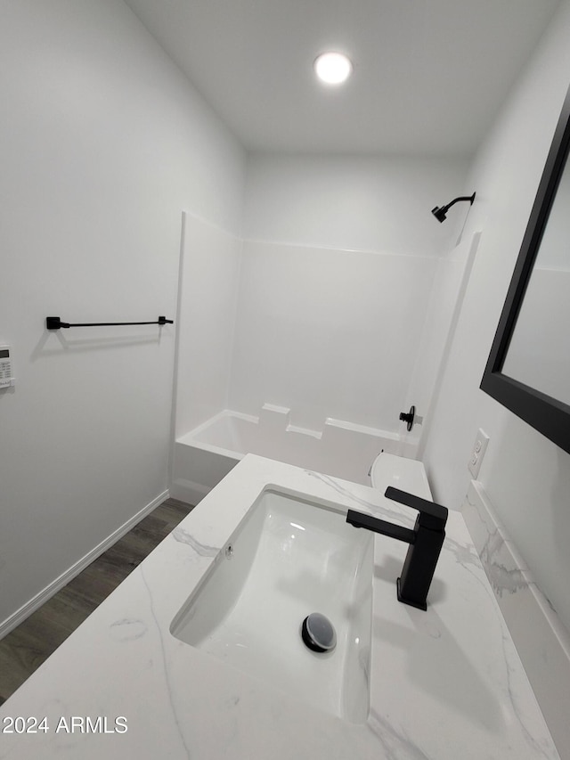 bathroom featuring hardwood / wood-style floors, sink, and shower / washtub combination