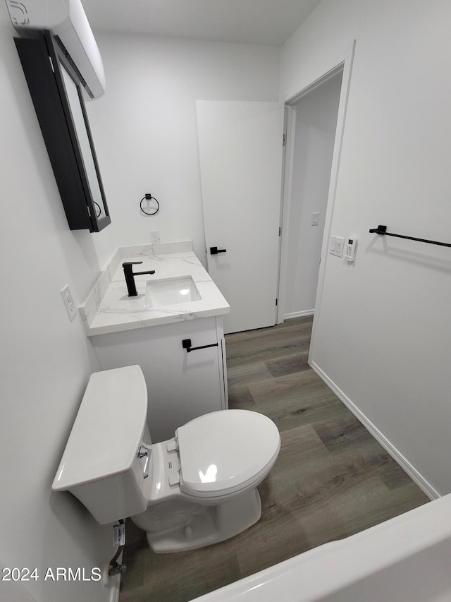 bathroom with toilet, vanity, and hardwood / wood-style flooring