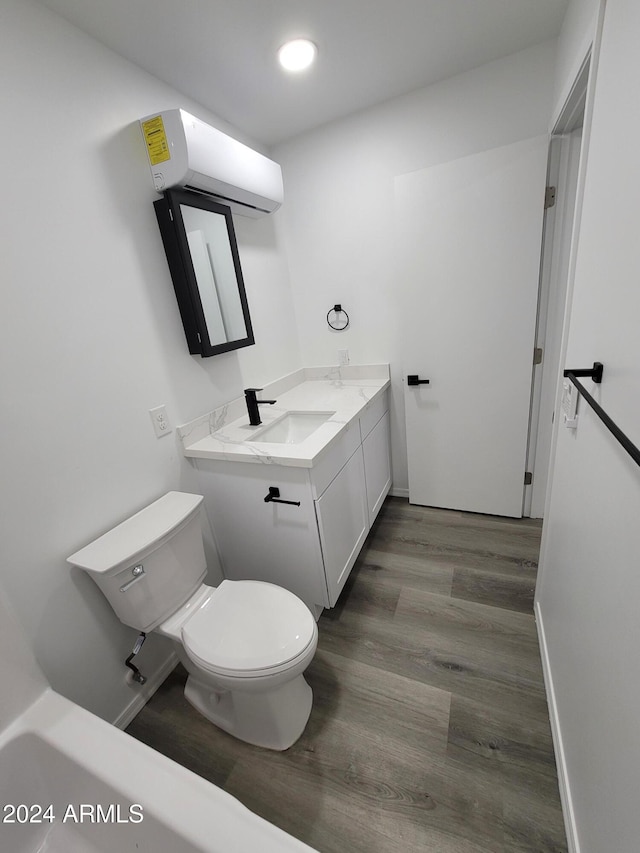 bathroom featuring toilet, vanity, a wall mounted air conditioner, and hardwood / wood-style flooring