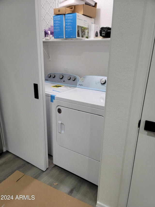 laundry room with hardwood / wood-style flooring and washer and dryer