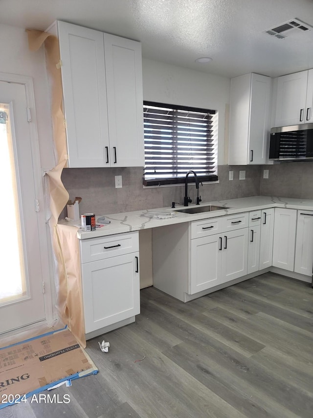 kitchen featuring a healthy amount of sunlight, white cabinetry, sink, and light hardwood / wood-style flooring