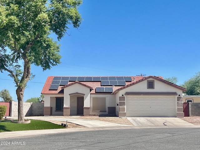 mediterranean / spanish-style home with a garage and solar panels