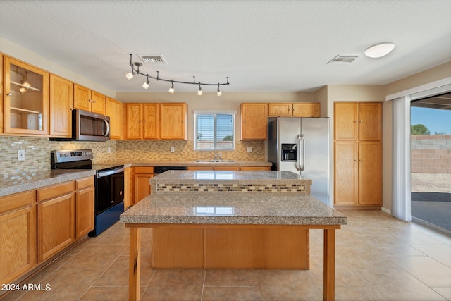 kitchen with a breakfast bar, appliances with stainless steel finishes, a kitchen island, and tasteful backsplash