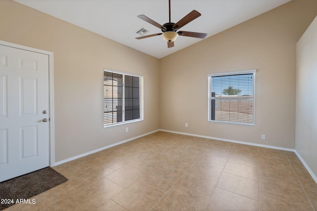 spare room with ceiling fan, lofted ceiling, and light tile patterned floors