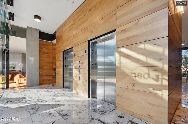 7180 E Kierland Blvd Unit 916, Scottsdale, AZ 85254 - hallway with elevator, wooden walls, and marble tiled floors