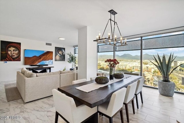 7180 E Kierland Blvd Unit 916, Scottsdale, AZ 85254 - dining room with a chandelier, light marble finish flooring, a mountain view, and a wall of windows