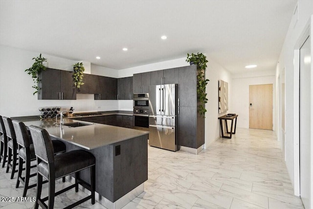 7180 E Kierland Blvd Unit 916, Scottsdale, AZ 85254 - kitchen with stainless steel appliances, a sink, light marble finish flooring, a peninsula, and recessed lighting